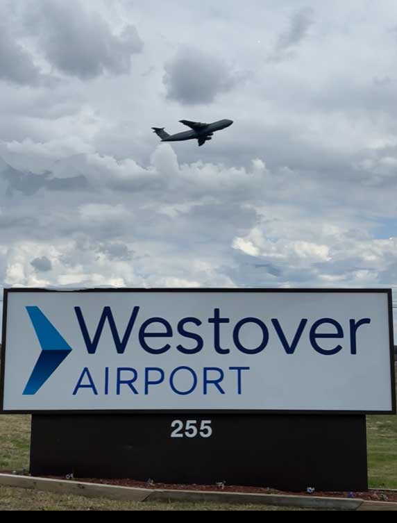 sign at westover airport with plane taking off